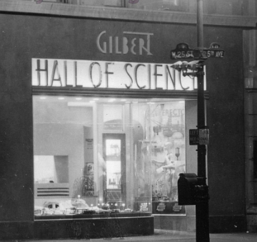 An enlarged section of the previous photo showing the American Flyer display window. Can you see the ghosts of two passersby who stopped long enough to be caught in this long time exposure? Look for their feet in front of the window.