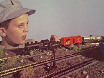 Boy & HO Rolling Stock A different version of this photo, showing a young boy looking at a variety of Gilbert HO rolling stock, found its way to a 1960 brochure, as shown in the next slide. Note that the difference in the expression on the boy's face in the advertising shown in the next slide.