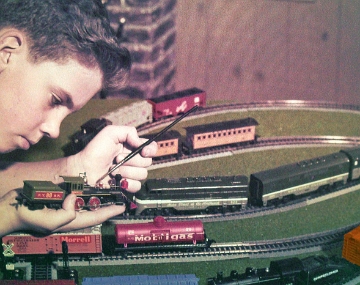 Boy Working on HO Trains The "better version" of this photo (at least in the eyes of Gilbert's advertising department) of a young boy apparently applying some touch up paint to an HO Frontiersman locomotive found its way into a 1959-60 HO brochure. The photo from the brochure is shown in the next slide. The main differences I can detect are the expression on the boy's face and the area of the model he is touching up. This is also one of the few transparencies that made its way to full color advertising.